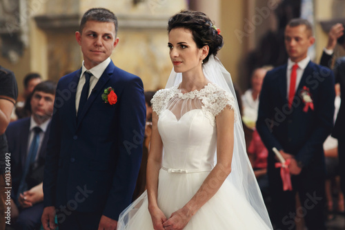 Faithful couple, bride and groom at wedding ceremony in church
