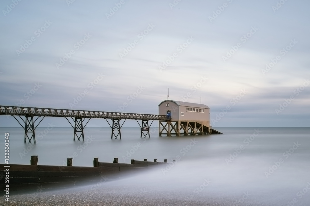 Beautiful long exposure landscape image of jetty at sea