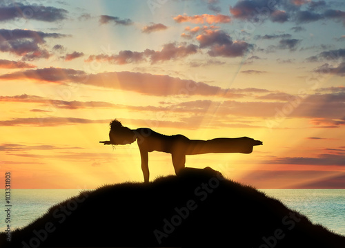 Silhouette of a girl practicing yoga © Prazis Images