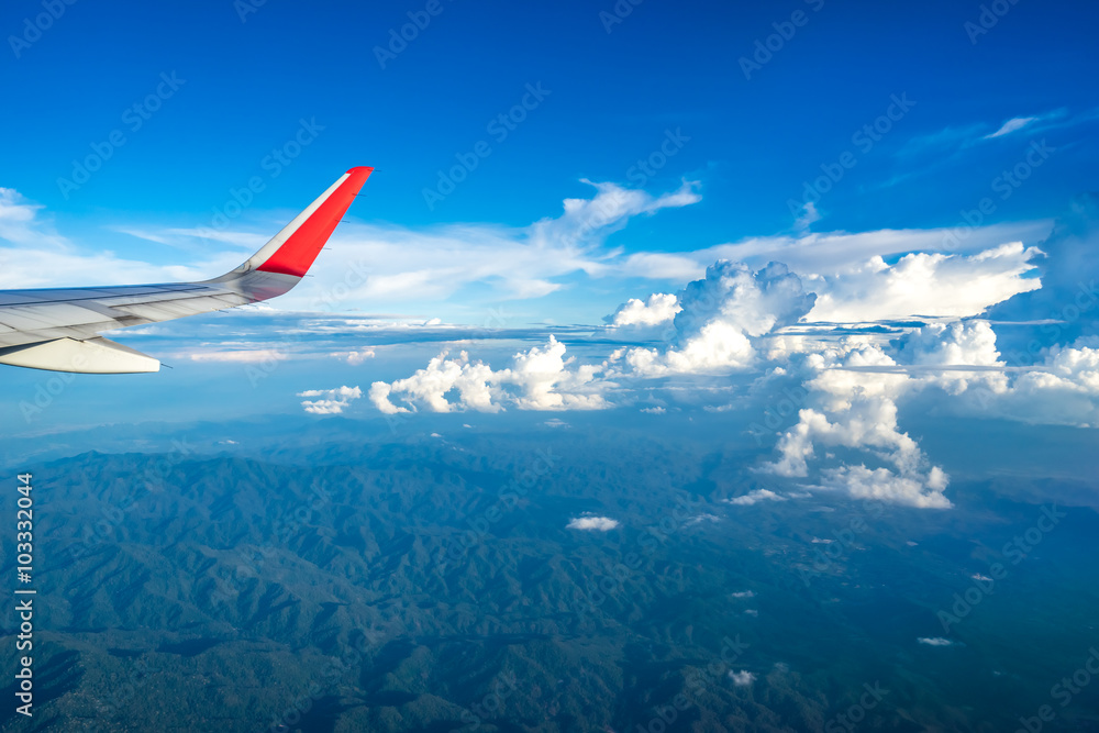 Fototapeta premium Clouds and sky as seen through window of an aircraft