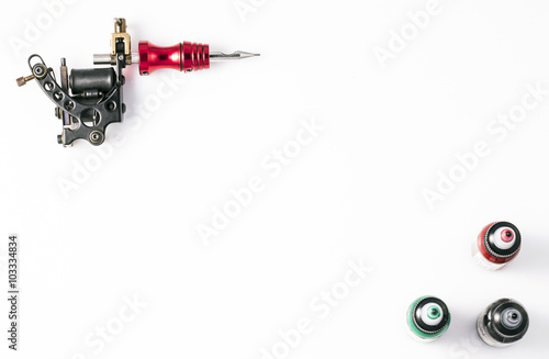 Tattoo machine and three bottles of ink isolated on white background. Tattoo gun.