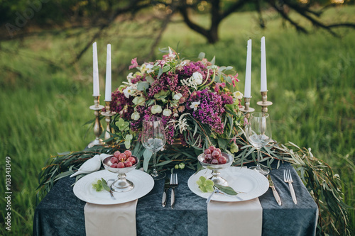 decorated table for two with a dark cloth decorated with floral