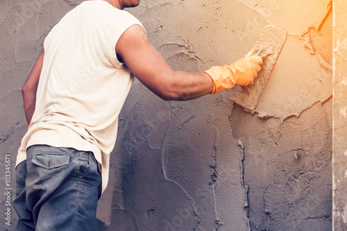 Foto man plasterer concrete working at wall of home construction buil