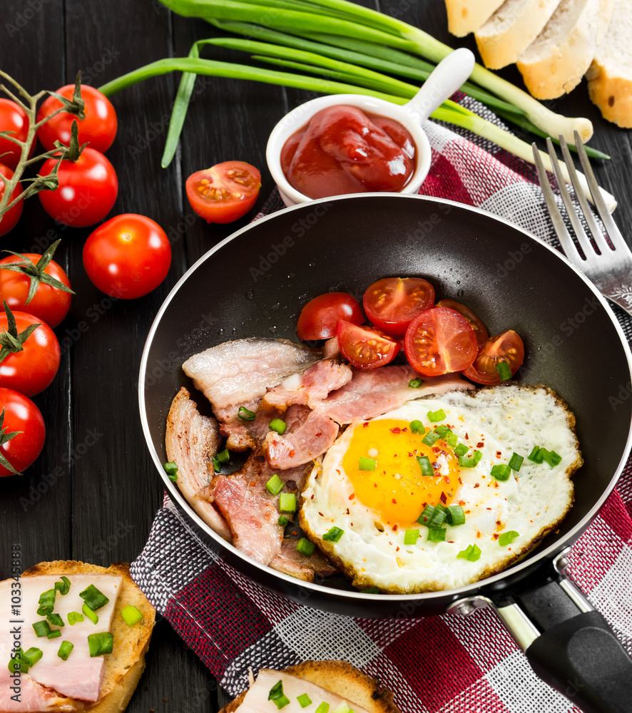 Fried eggs with ham in pan on black background. Fried eggs with ham in pan on black background.