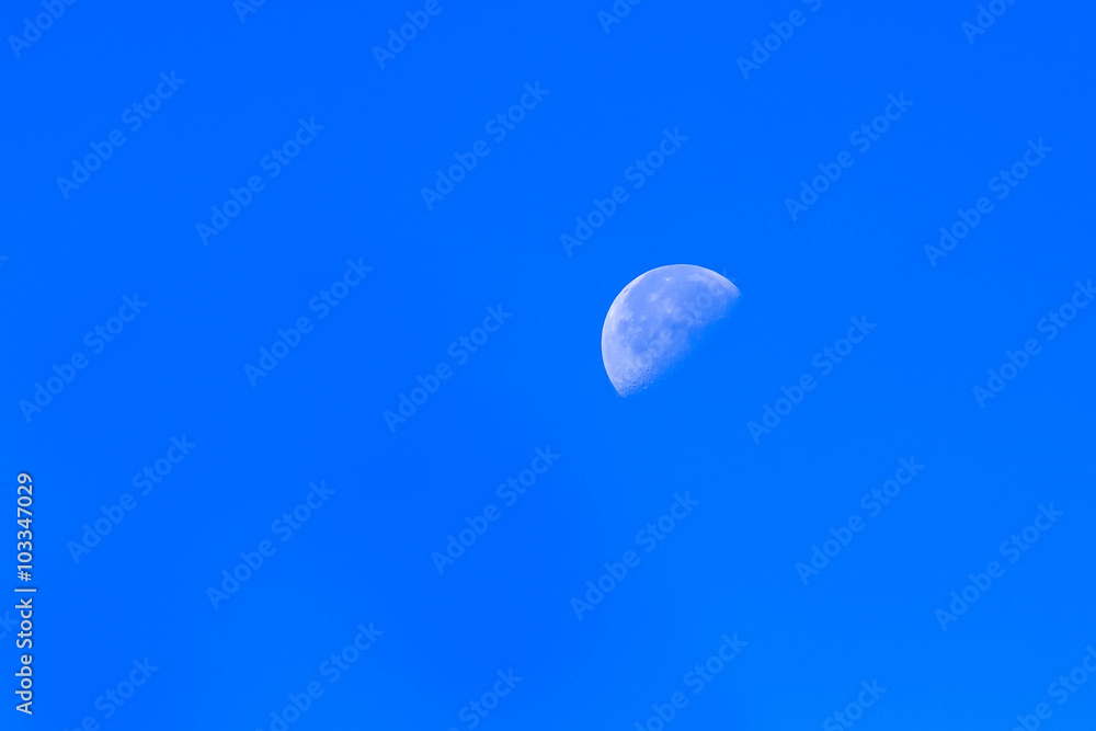 the white moon visible on a clear sky blue day the white moon visible on a clear sky blue day