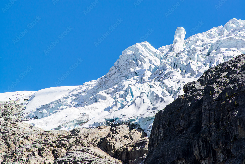 deserted glacier and snow above rocks of a mountains under a blue sky in the rockies of british columbia canada