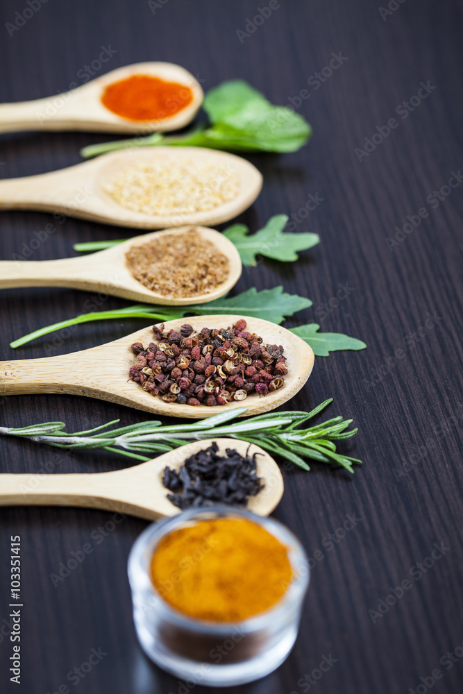 Colorful spices and wooden cutlery Colorful spices and wooden cutlery