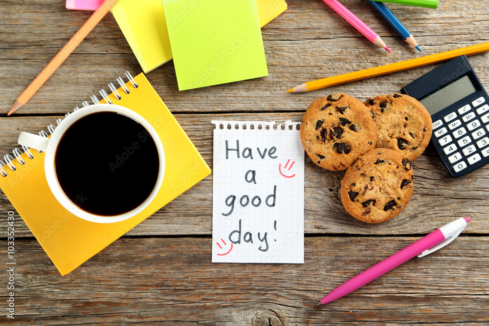 Piece of note paper with cup of coffee and cookies on grey woode