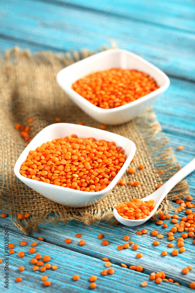 Red lentils in bowl on a blue wooden table Red lentils in bowl on a blue wooden table