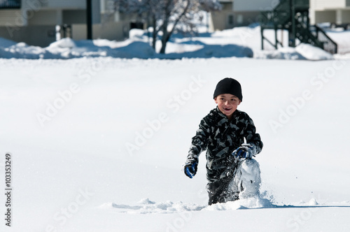 Cute boy playing in the snow. photo