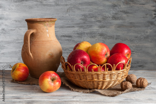 Still life in a rustic style: red apples and an old crock.