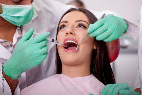 dentist giving anesthesia to the patient