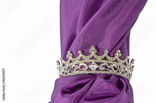 Silberne Krone mit feinem lila Stoff freigestellt auf weißem Hintergrund