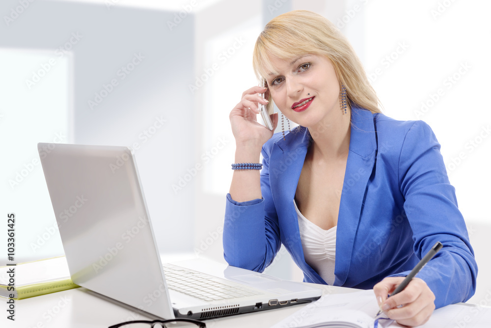 Beautiful businesswoman working sitting at her desk in the office Beautiful businesswoman working sitting at her desk in the office