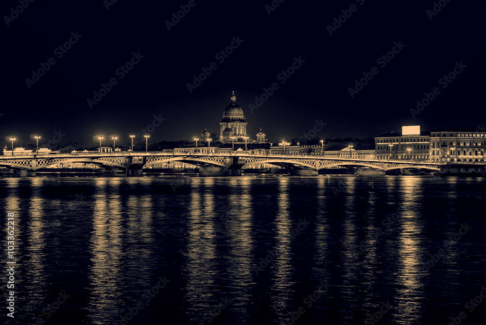 Fototapeta premium Night view of the English embankment, St. Isaac's Cathedral and Annunciation bridge in St. Petersburg, monochrome retro effect