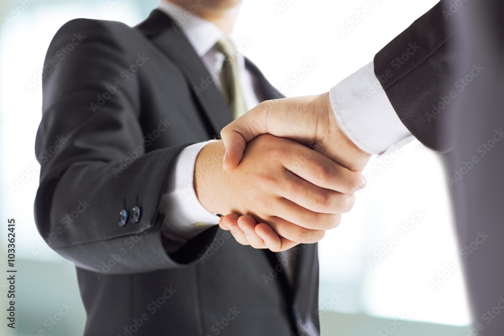 business and office concept - businessman shaking hands each oth