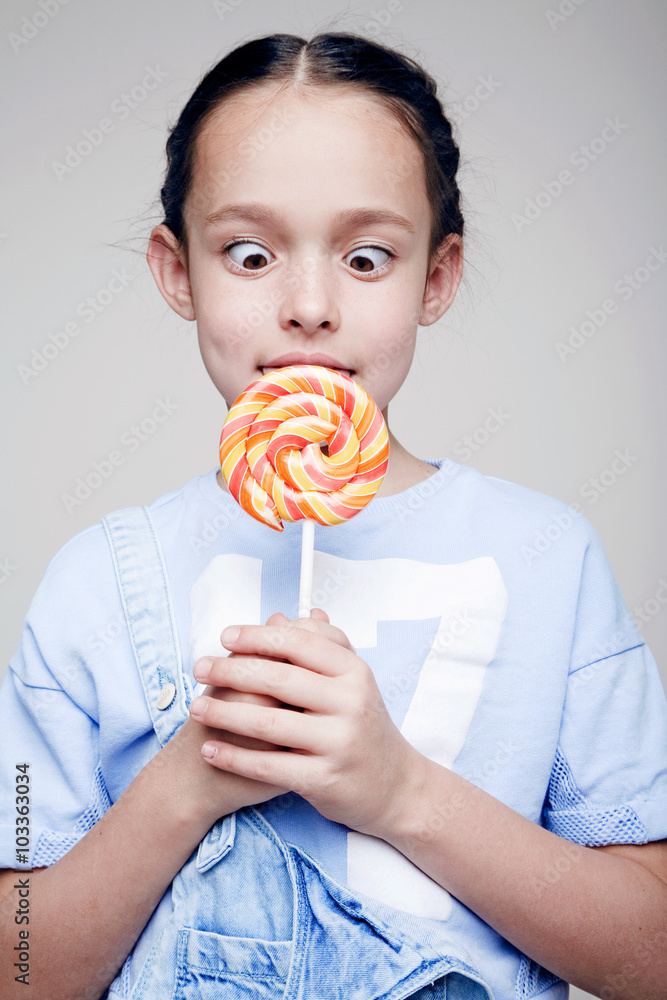 Little charming girl and a big lollipop