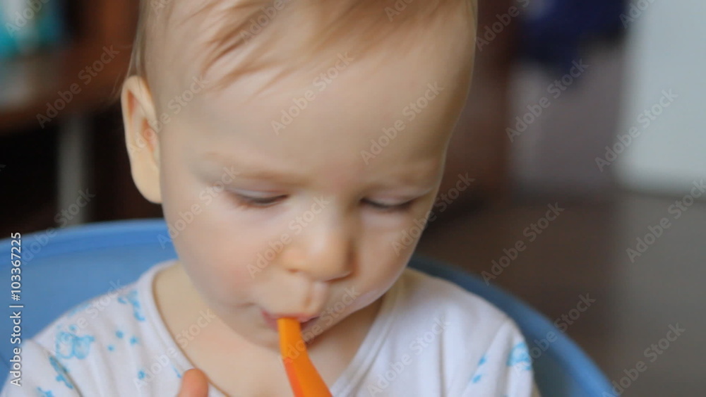 infant spits out the nipple and played with a plastic spoon infant spits out the nipple and played with a plastic spoon