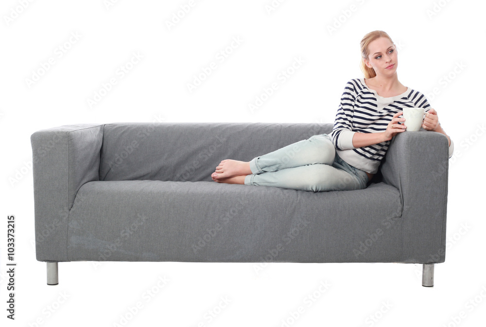 a pretty blonde lady wearing casual clothes, lounging on a grey sofa. isolated on a white background. a pretty blonde lady wearing casual clothes, lounging on a grey sofa. isolated on a white background.