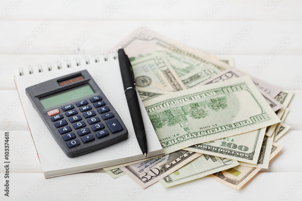 Calculator, notebook, pen and cash money on white table. Finance concept. Calculator, notebook, pen and cash money on white table. Finance concept.