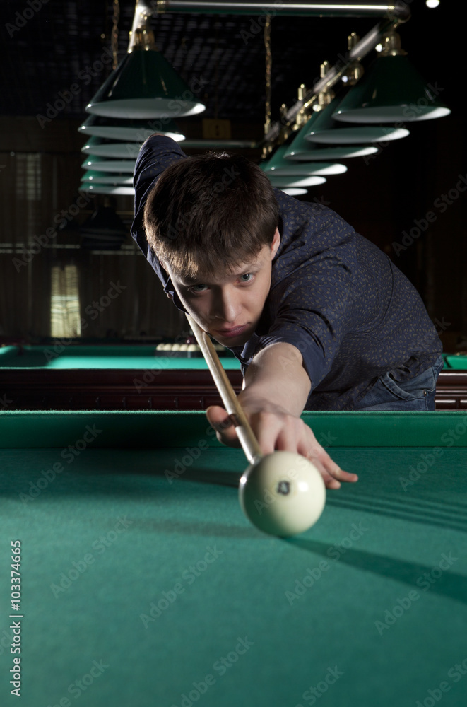 Fototapeta premium Young man playing billiards