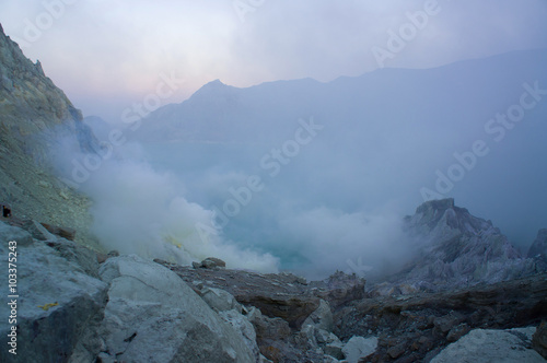 Ijen volcano in East Java contains the world's largest acidic volcanic crater lake, called Kawah Ijen, spewing out sulphur smoke in the morning. Sun is hidden in mist.