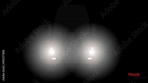Silhouette of truck with headlights on black background
