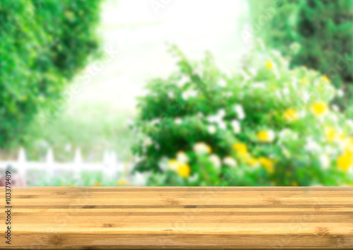 Empty wood table top for product disply with blur natural garden