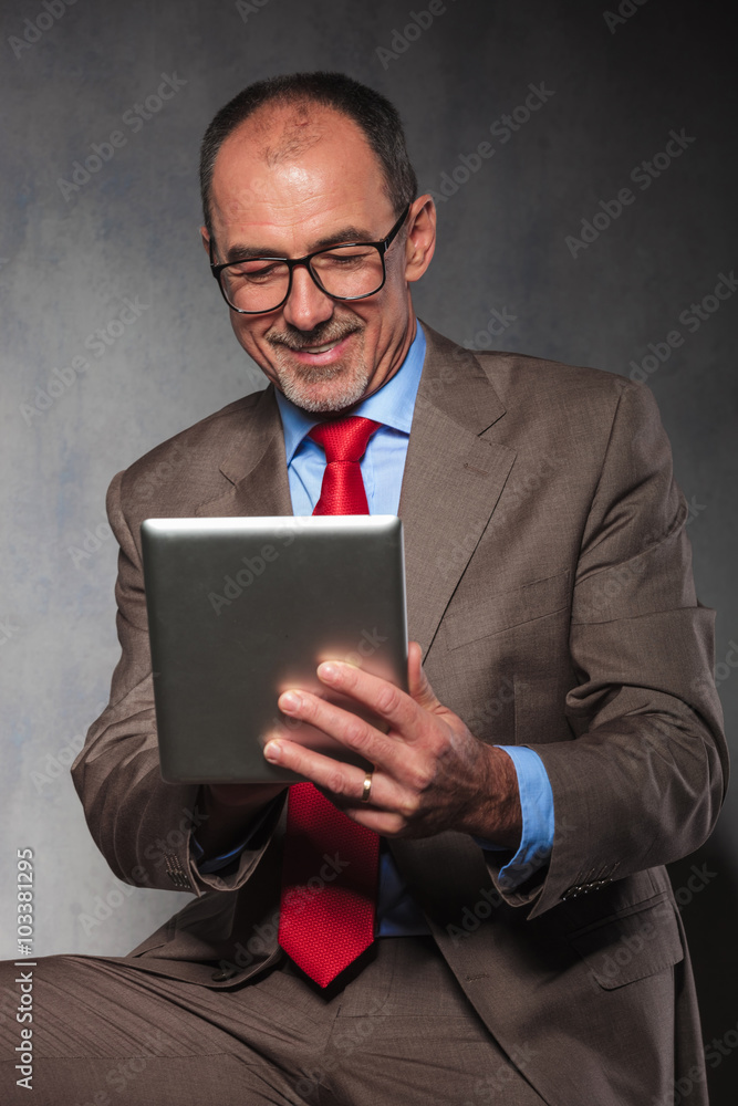 handsome senior looking down at his tablet