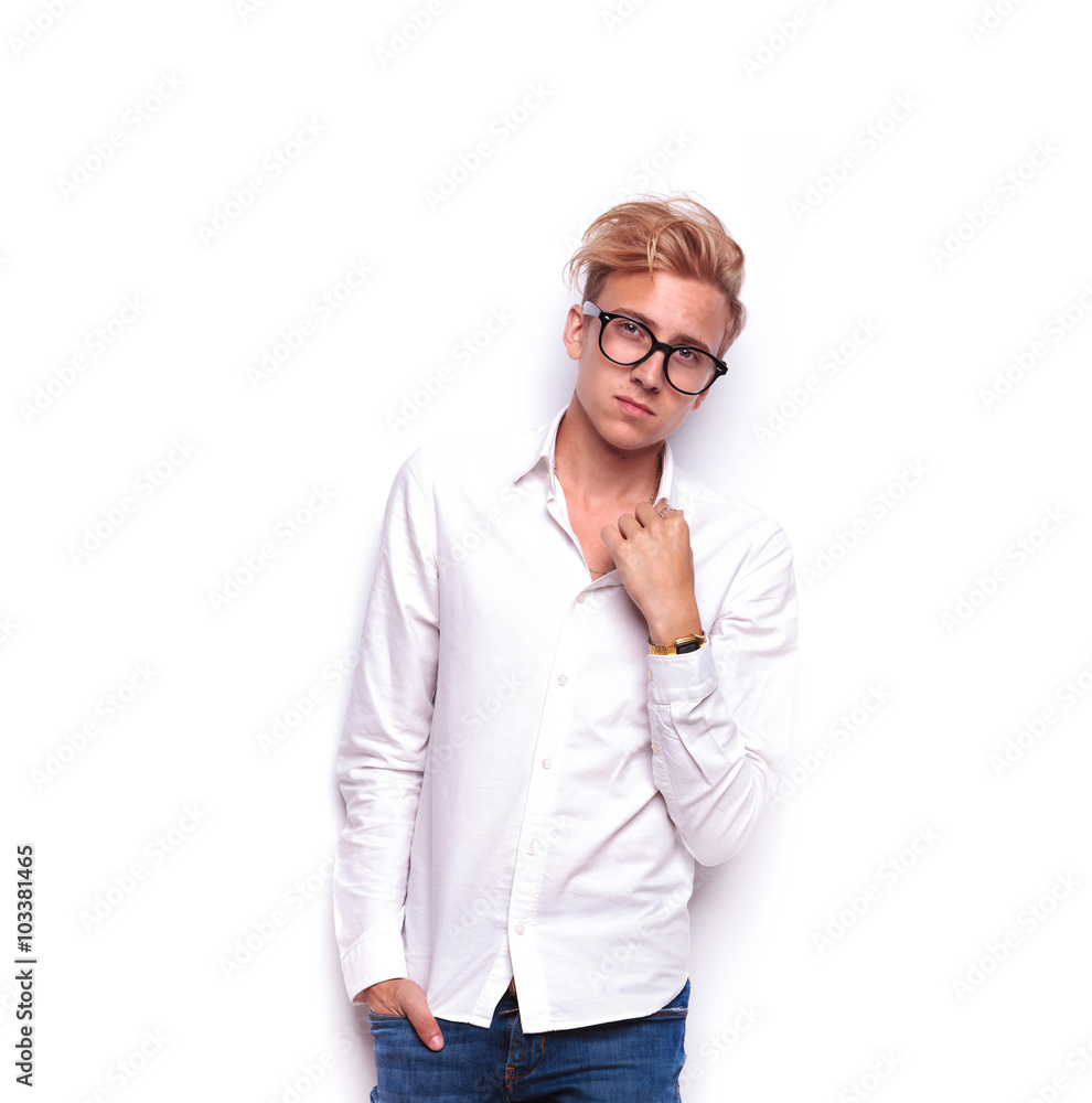 young blonde hipster wearing glasses posing with hand in pocket young blonde hipster wearing glasses posing with hand in pocket