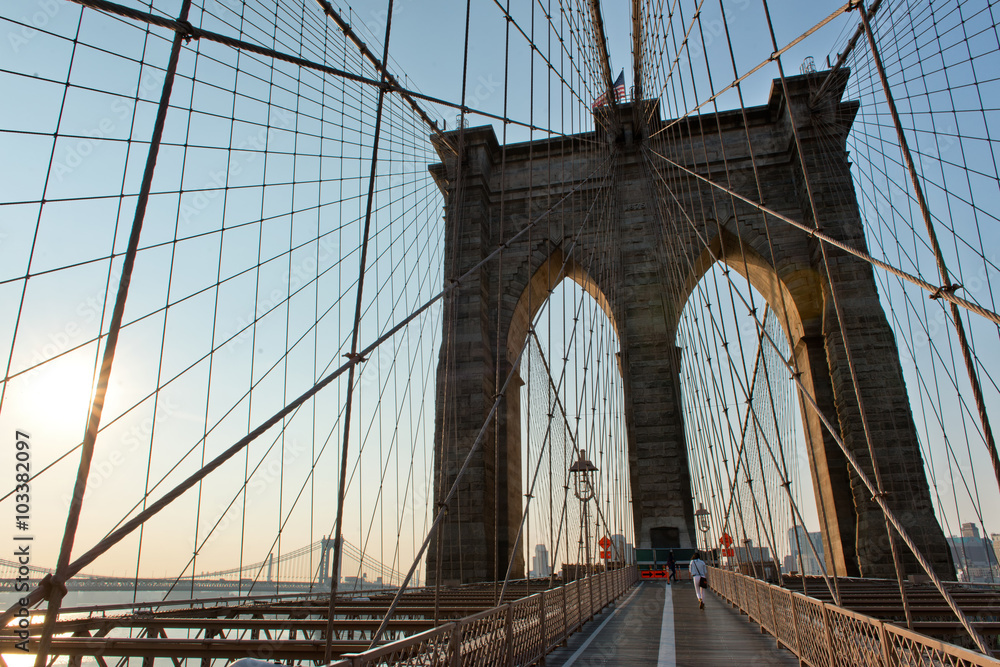 Naklejka premium Słynna ścieżka i łuki Brooklyn Bridge o zachodzie słońca