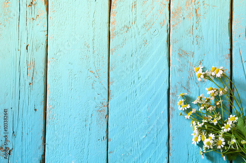 Fototapeta Naklejka Na Ścianę i Meble -  top view image of daisy flowers on blue wooden table. vintage filtered
