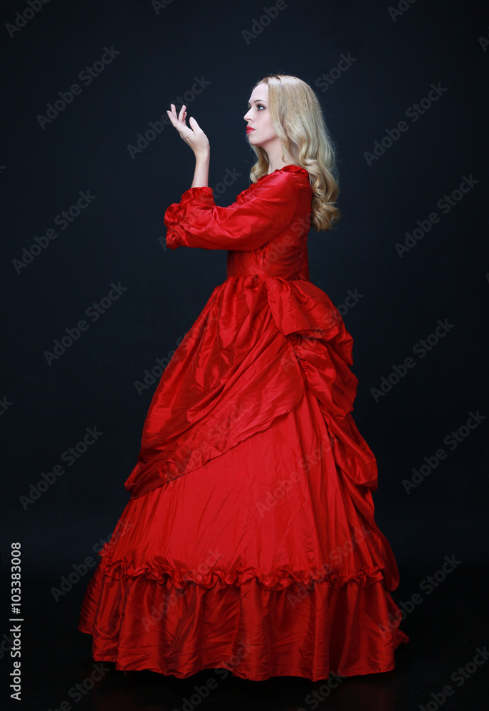 full length portrait of a beautiful blonde woman wearing a historical red silk, victorian era ball gown. full length portrait of a beautiful blonde woman wearing a historical red silk, victorian era ball gown.