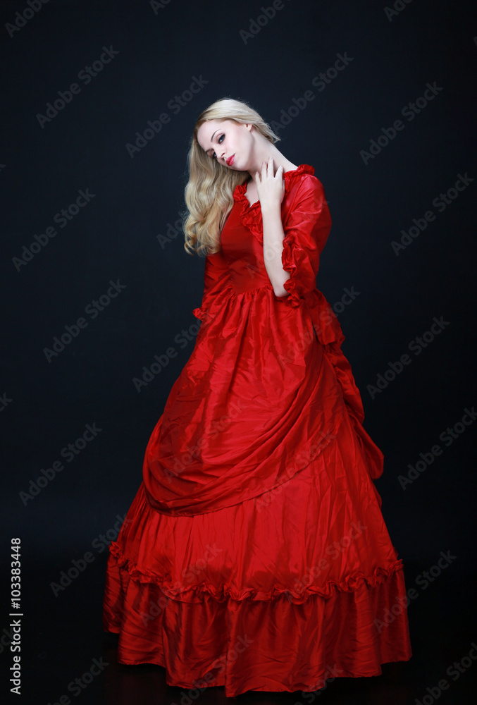 full length portrait of a beautiful blonde woman wearing a historical red silk, victorian era ball gown. full length portrait of a beautiful blonde woman wearing a historical red silk, victorian era ball gown.
