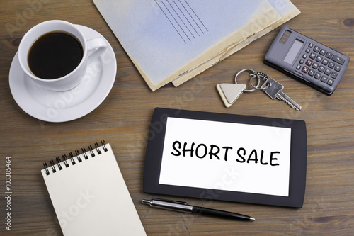 Short Sale. Text on tablet device on a wooden table