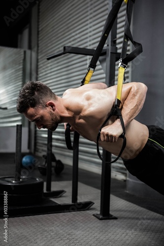 Shirtless man hanging at the rope