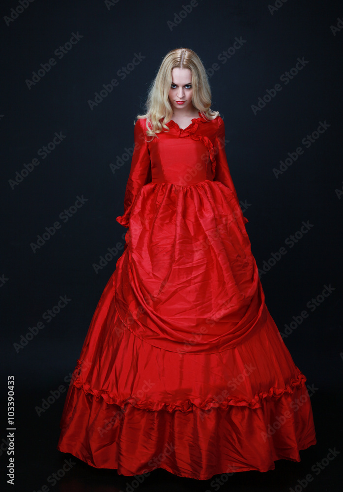 full length portrait of a beautiful blonde woman wearing a historical red silk, victorian era ball gown. full length portrait of a beautiful blonde woman wearing a historical red silk, victorian era ball gown.