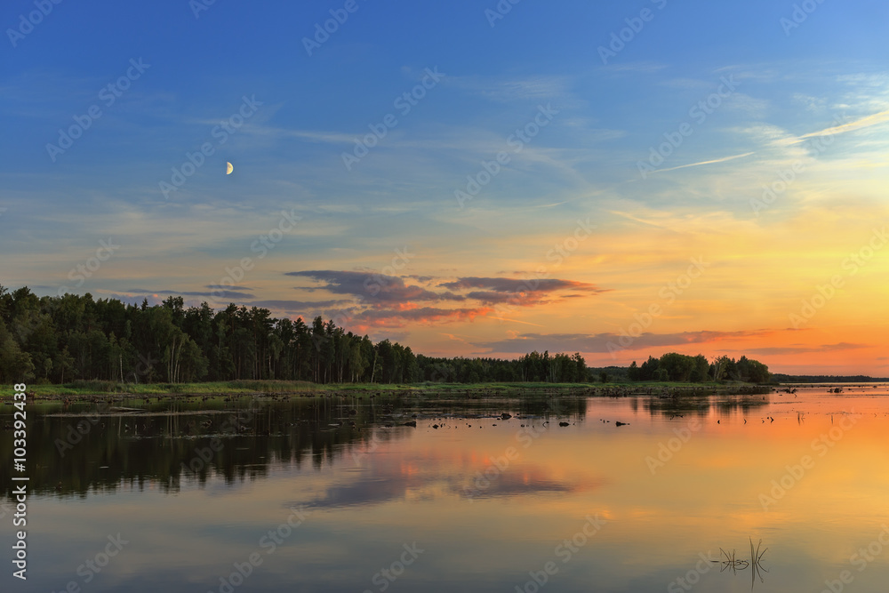 .Beautiful sunset over the forest and lake.
