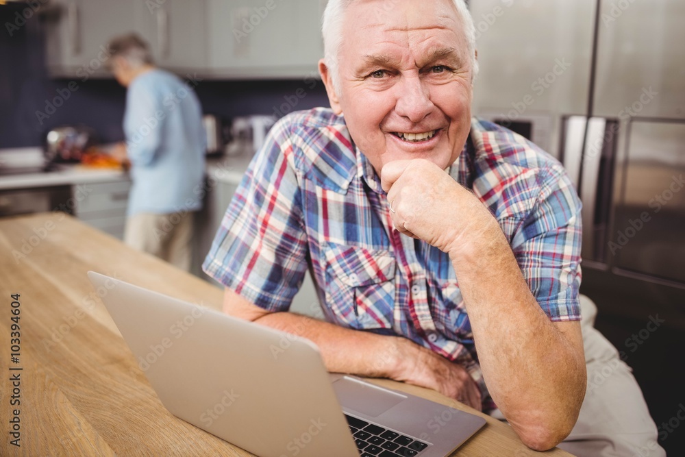 Portrait of happy senior man using laptop and woman working in k Portrait of happy senior man using laptop and woman working in k