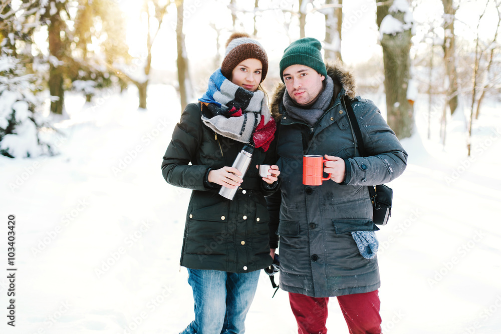 Young couple drinking tea in the forest