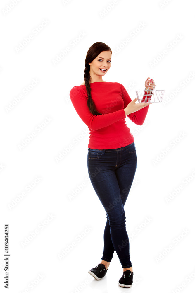 Smiling young woman holding small empty shopping cart Smiling young woman holding small empty shopping cart