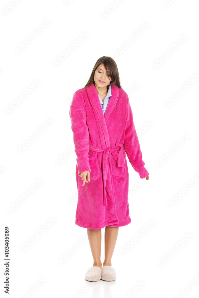 Woman in pink bathrobe pointing down. Woman in pink bathrobe pointing down.