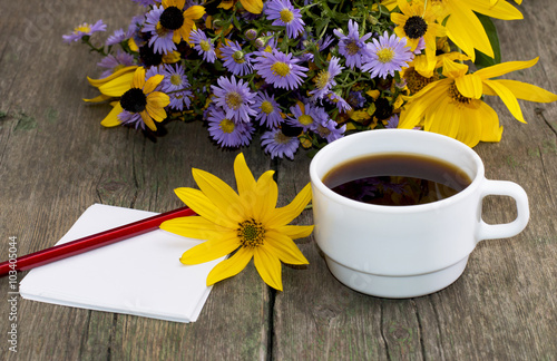 bouquet of wild flowers, coffee and pencil with paper