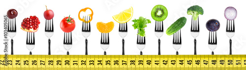 Fruits and vegetables on fork with measuring tape
