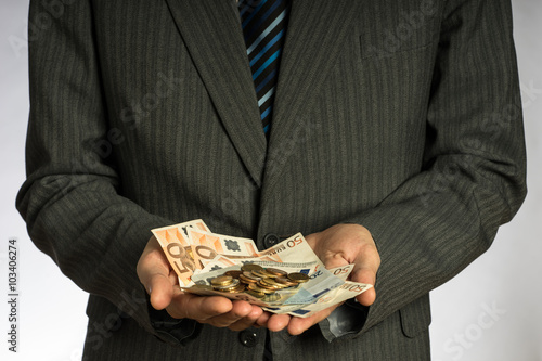 Businessman hand holding money, euro bills. Banknotes isolated gray background. Hand holding out a stack of fifty euros