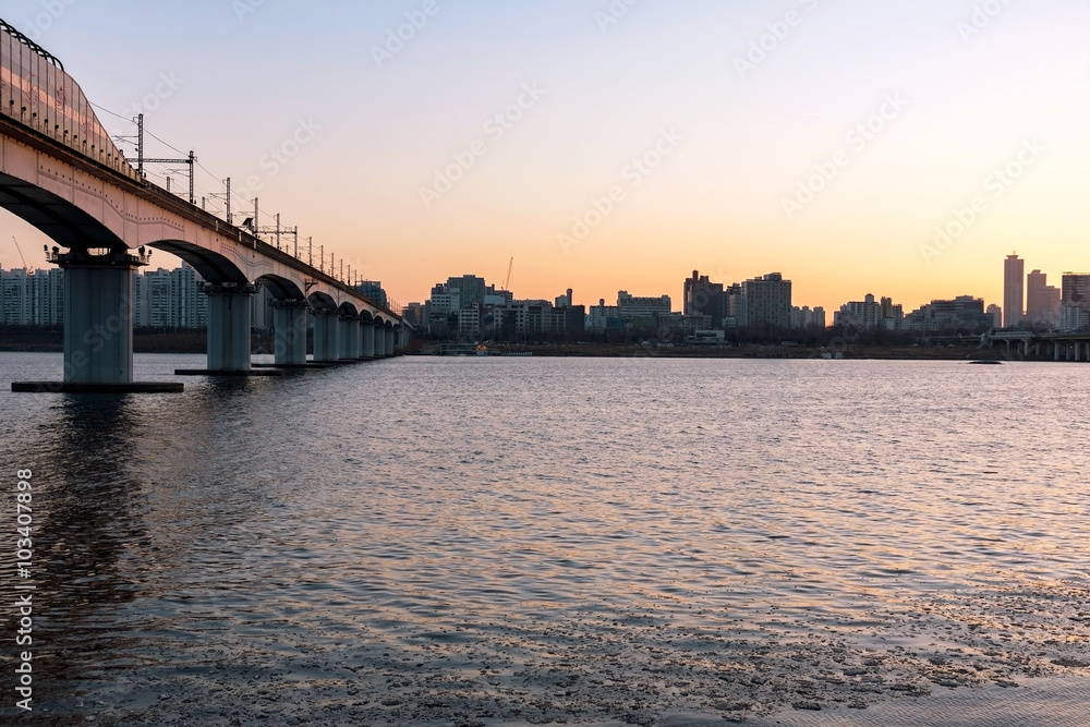 Buildings and bridge at sunset