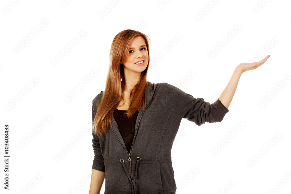Teenage woman presenting something on open palm Teenage woman presenting something on open palm