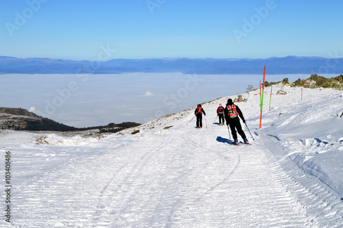 Three skiers descend from mountain peak, Cherni Vrah, Vitosha Mountain, Bulgaria photo