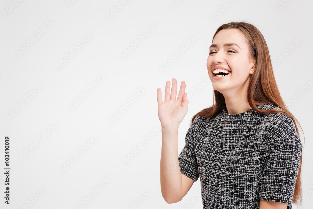 Cheerful pretty young woman standing and laughing Cheerful pretty young woman standing and laughing