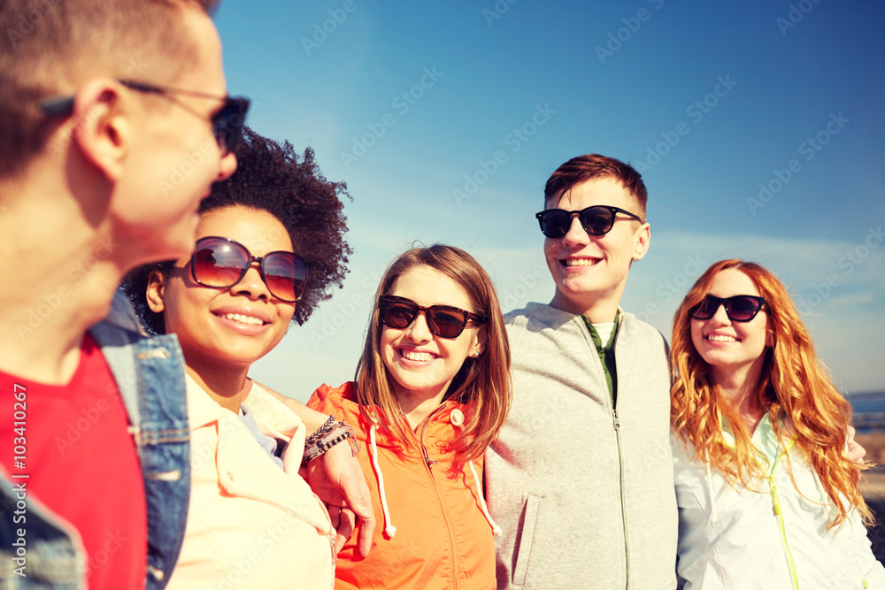 happy teenage friends in shades talking on street happy teenage friends in shades talking on street